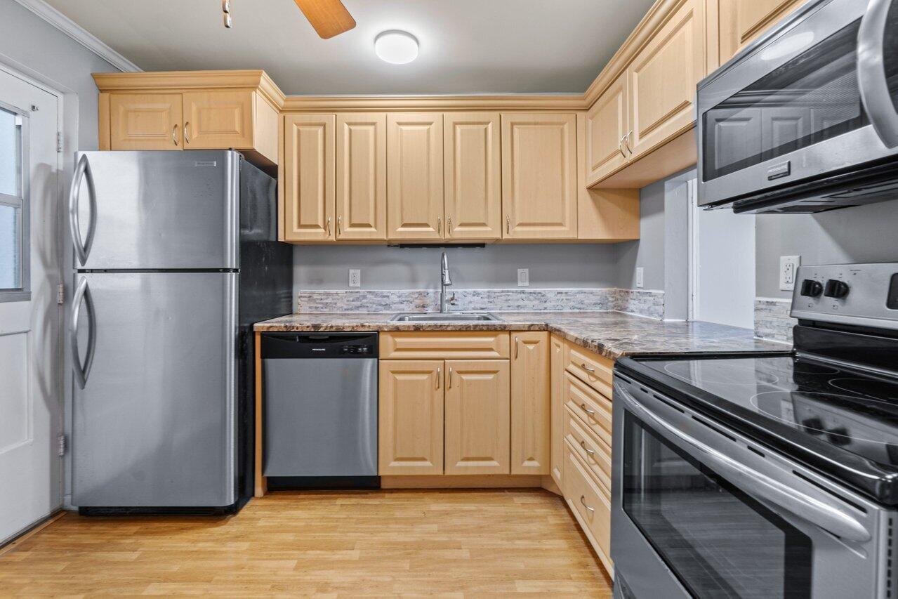 5700 Northwest 2nd Avenue, Unit 401 Boca Raton, FL 33487 - Photo 8 of 30 a kitchen with a refrigerator sink and stove