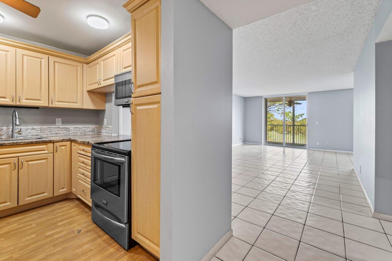 5700 Northwest 2nd Avenue, Unit 401 Boca Raton, FL 33487 - Photo 10 of 30 a kitchen with a stove a sink and a refrigerator