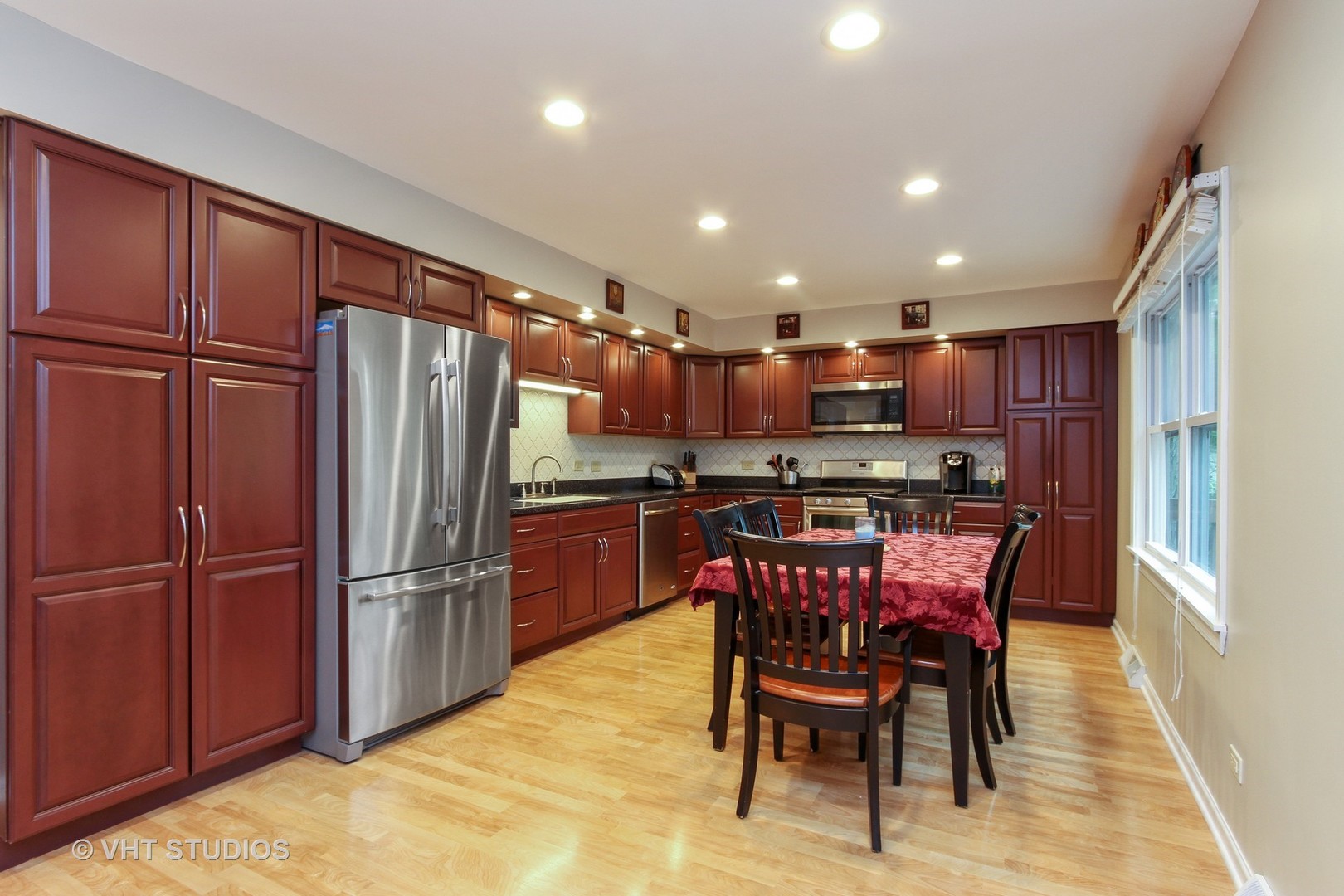 127 Hickory Road Oakwood Hills, IL 60013 - Photo 6 of 28 a kitchen with stainless steel appliances kitchen island granite countertop a refrigerator a stove a sink a dining table and chairs with wooden floor