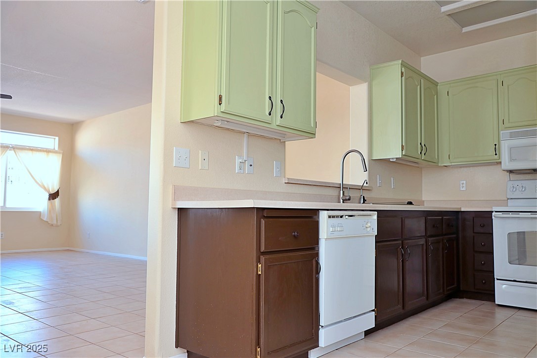 3349 Partridge Run Street Laughlin, NV 89029 - Photo 17 of 58 Kitchen featuring light tile patterned floors, white appliances, and light countertops