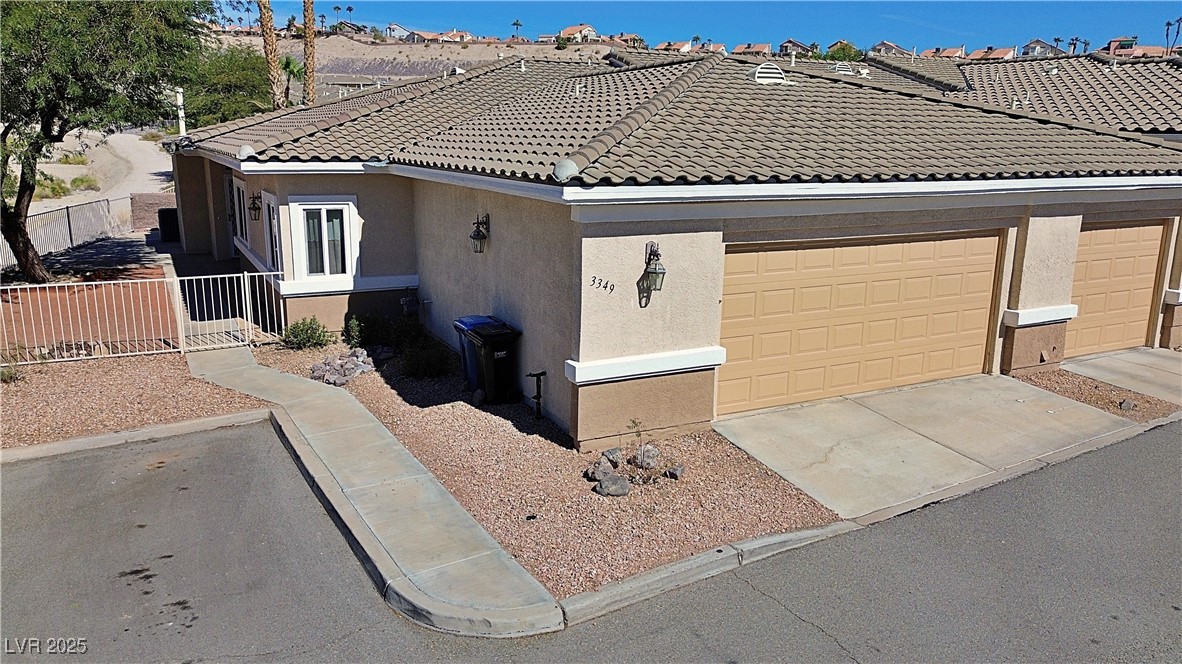 3349 Partridge Run Street Laughlin, NV 89029 - Photo 2 of 58 View of front facade featuring stucco siding, a tile roof, and concrete driveway