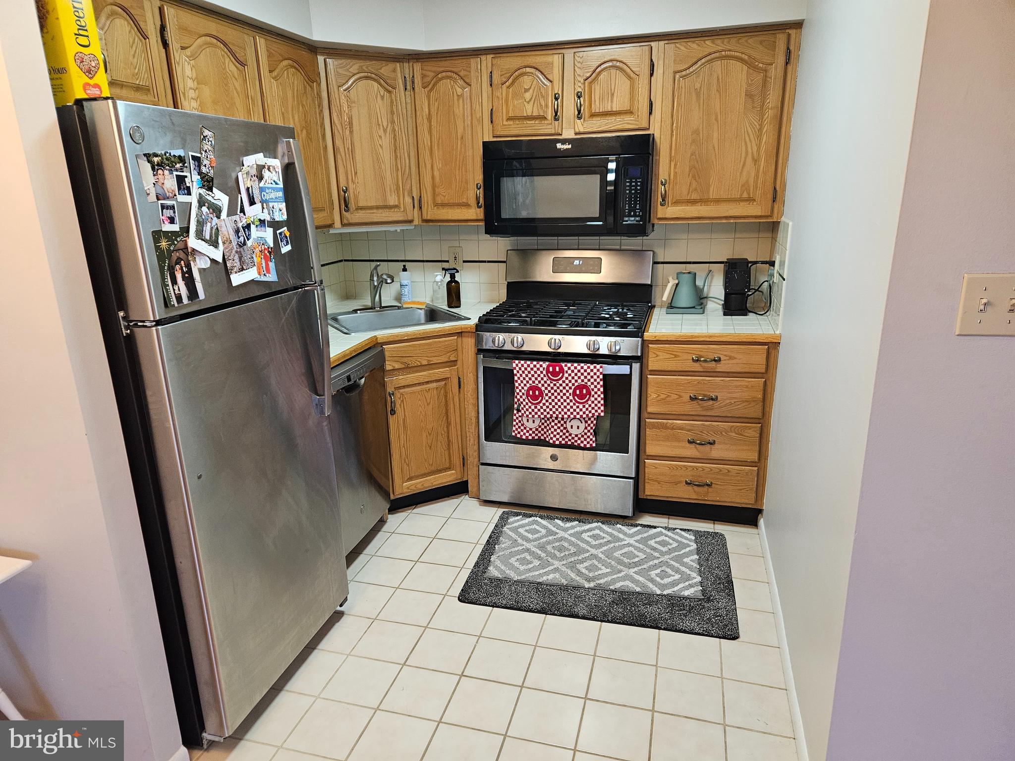 200 North Wayne Avenue, Unit 9 Wayne, PA 19087 - Photo 6 of 10 a kitchen with stainless steel appliances a refrigerator stove microwave and sink