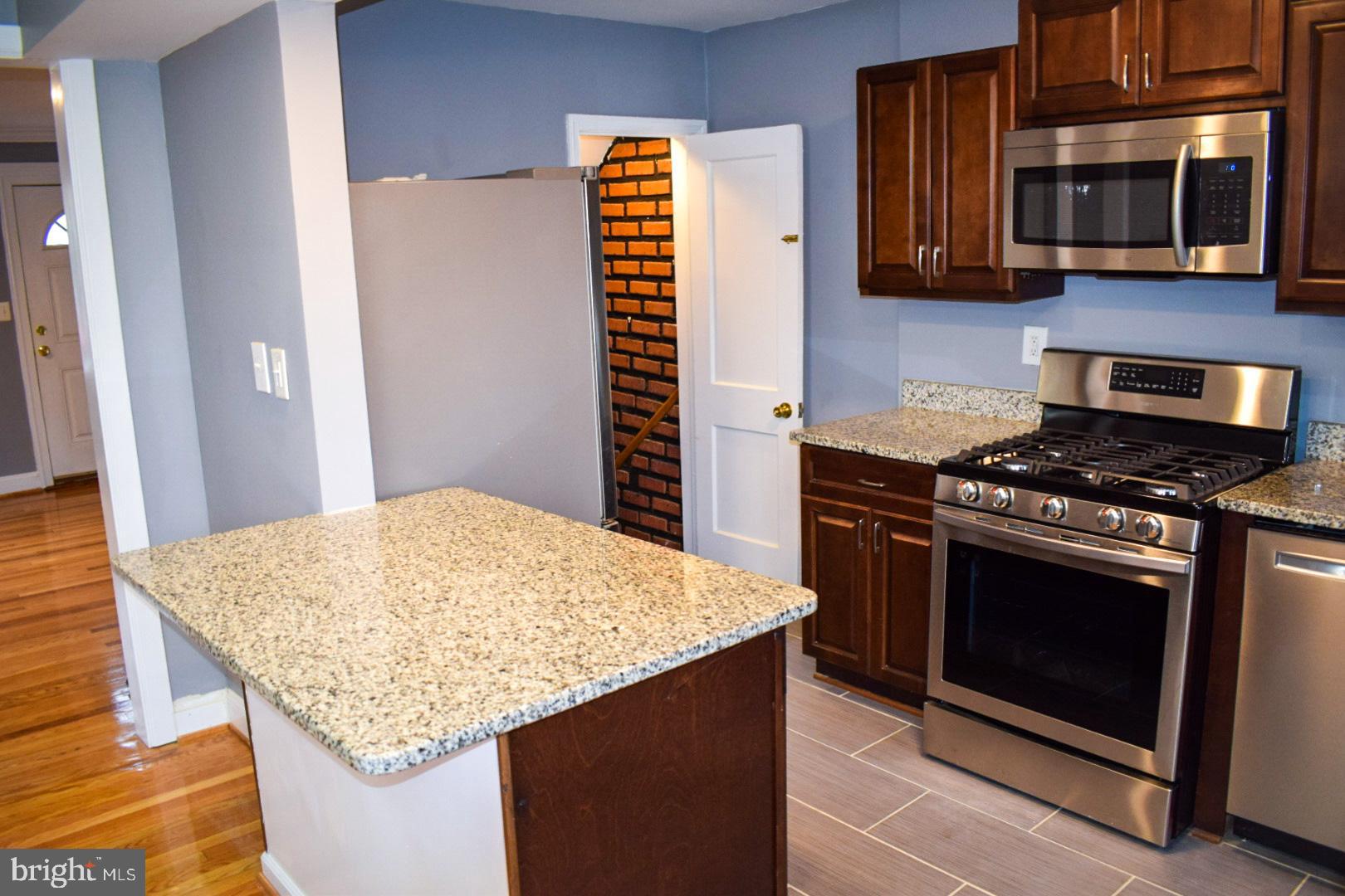 4227 Flowerton Road Baltimore, MD 21229 - Photo 15 of 45 a kitchen with stainless steel appliances granite countertop a stove and a microwave