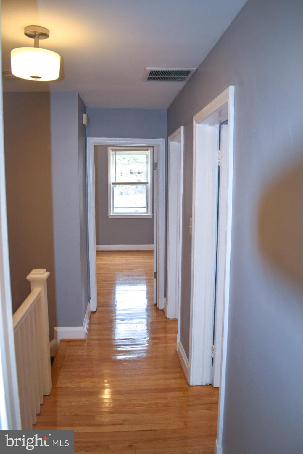 4227 Flowerton Road Baltimore, MD 21229 - Photo 18 of 45 a view of a hallway with wooden floor and a living room