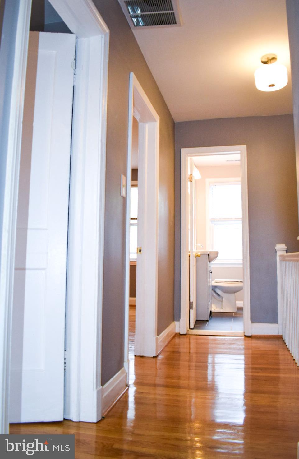 4227 Flowerton Road Baltimore, MD 21229 - Photo 26 of 45 a view of a hallway with wooden floor and a bathroom