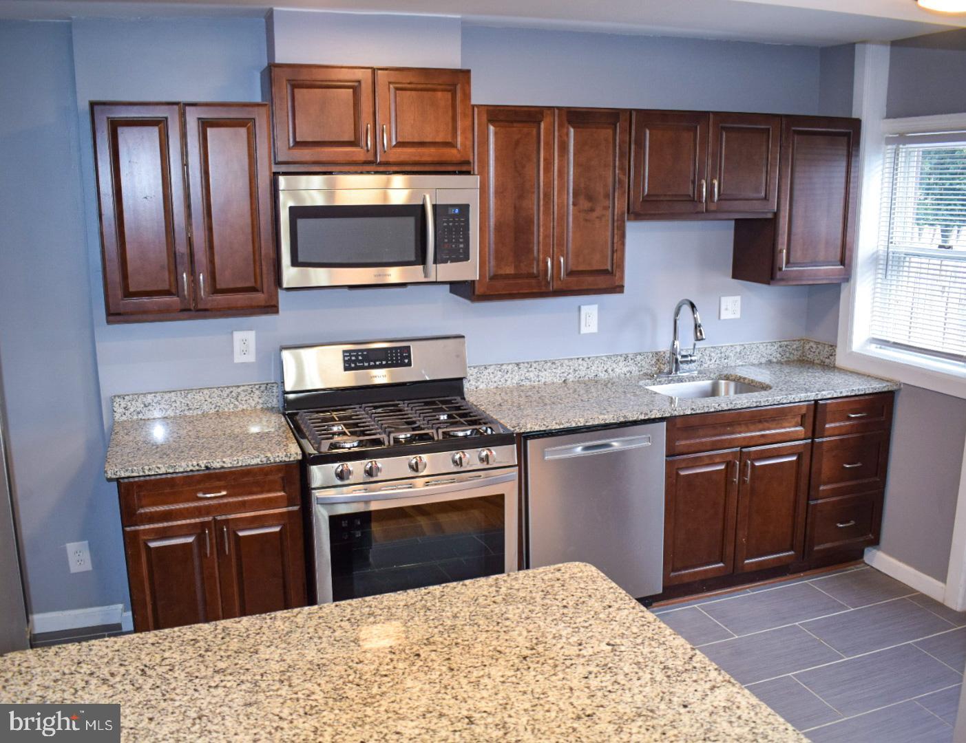 4227 Flowerton Road Baltimore, MD 21229 - Photo 7 of 45 a kitchen with stainless steel appliances granite countertop a stove microwave and sink