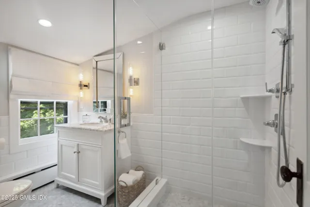 a bathroom with a sink a large mirror and shower