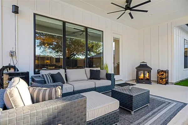 a living room with furniture ceiling fan and a large window