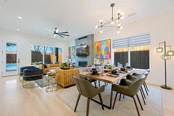 a dining room with furniture a chandelier and wooden floor