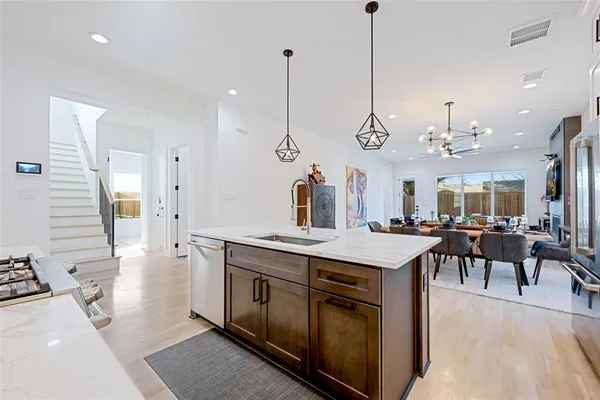 a view of a dining room and livingroom with furniture wooden floor a chandelier