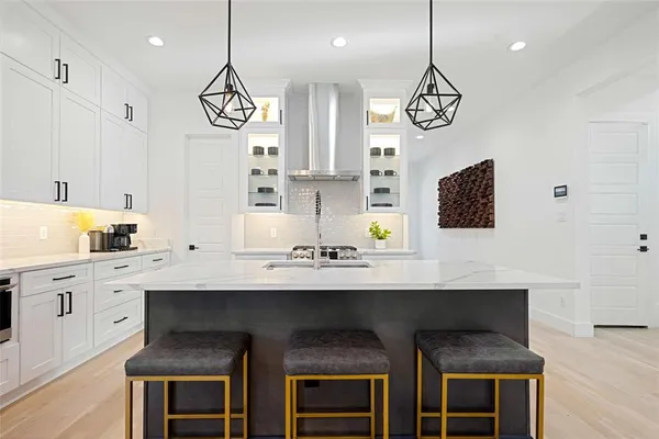 a kitchen with cabinets a island a stove and a fireplace