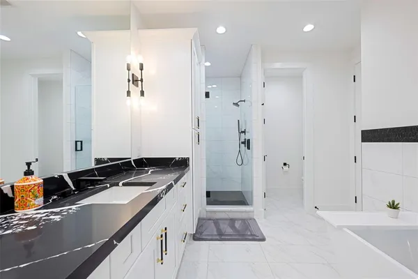 a bathroom with a granite countertop sink a mirror and a shower