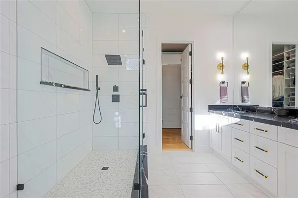 a bathroom with a granite countertop sink a large mirror and shower