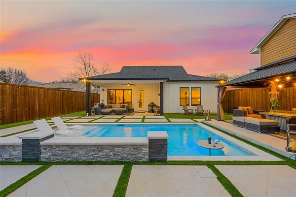 a view of a house with swimming pool and sitting area