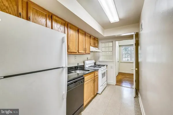 a kitchen with a stove a refrigerator and a sink