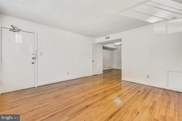 a view of an empty room with wooden floor