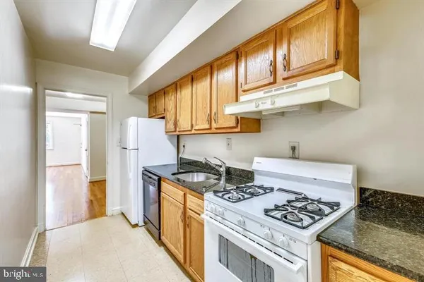 a kitchen with stainless steel appliances granite countertop a stove a refrigerator and a cabinets