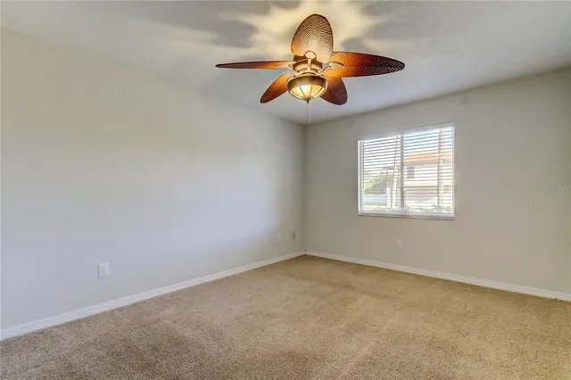 a view of a room with a ceiling fan and window