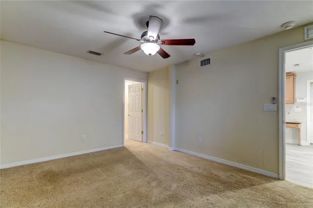 an empty room and chandelier fan