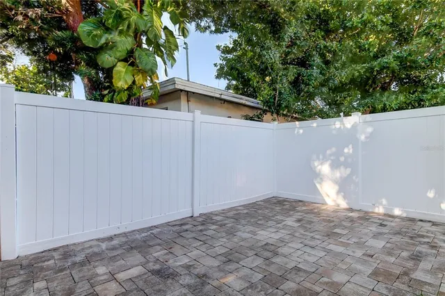a view of a house with a large window and potted plants