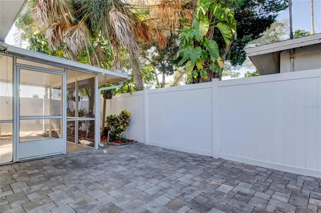 a vase of flowers sitting on a floor in front of a window