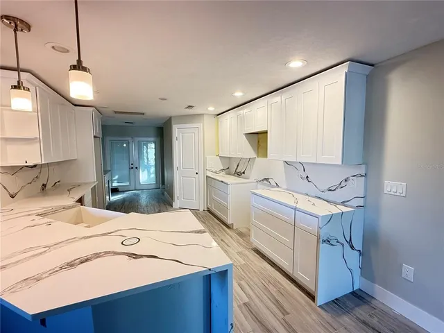 a kitchen with kitchen island a sink appliances and cabinets