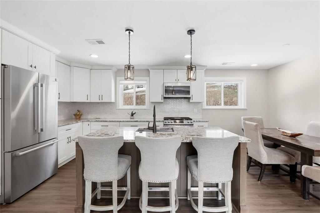 161 Harmony Road Wexford, PA 15090 - Photo 8 of 34 a kitchen with stainless steel appliances kitchen island granite countertop a dining table chairs refrigerator and sink