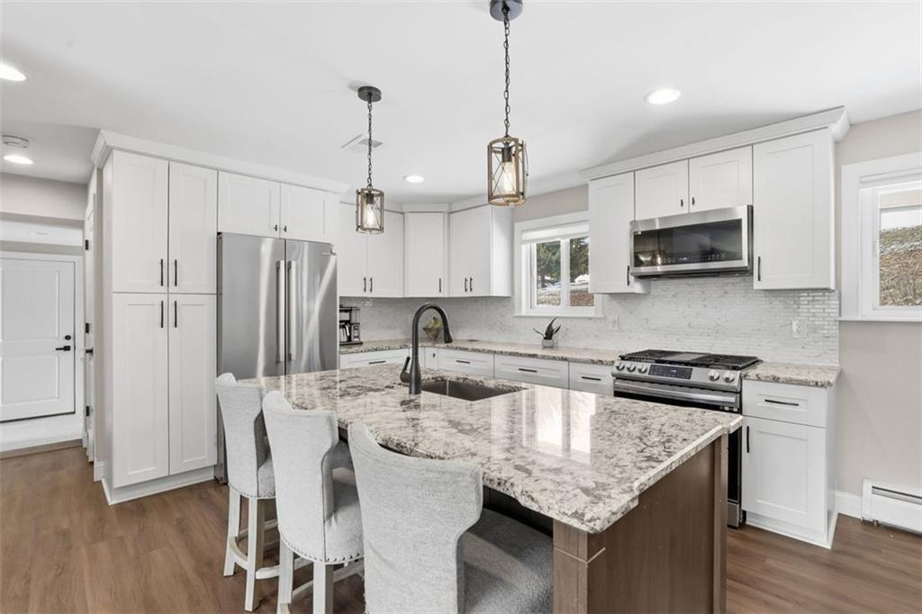 161 Harmony Road Wexford, PA 15090 - Photo 9 of 34 a kitchen with stainless steel appliances granite countertop a stove a refrigerator a kitchen island a sink and wooden floor