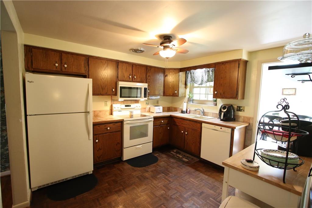 226 Waynesburg Road Washington, PA 15301 - Photo 3 of 24 Plenty of Wood Cabinets in 11x11 Kitchen w/ Beautiful Paquet Wood Floors, Ceramic Tiled Counter Tops and Door leading into 1st Floor Family Sun Room. All Appliances Included
