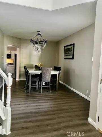 a dining room with furniture a chandelier and wooden floor