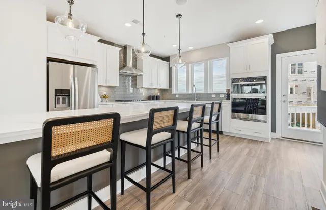 a kitchen with stainless steel appliances granite countertop wooden floor window and cabinets