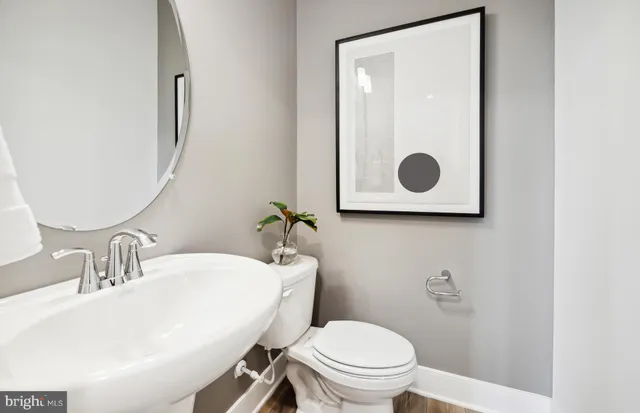 a bathroom with a toilet a sink and mirror