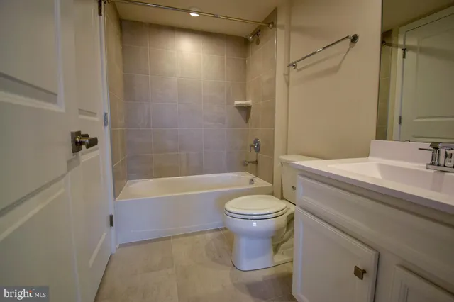 a bathroom with a sink a toilet a mirror a bathtub and shower