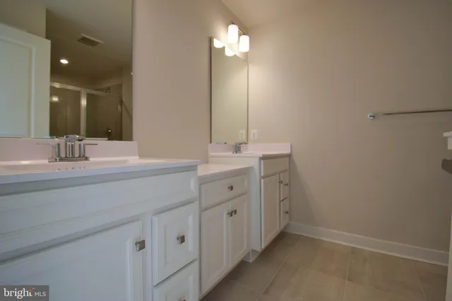 a bathroom with a double vanity sink and a mirror