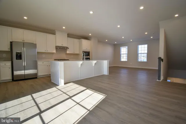 a view of kitchen with stainless steel appliances refrigerator sink and cabinets