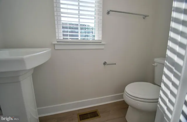 a white toilet sitting next to a bath tub