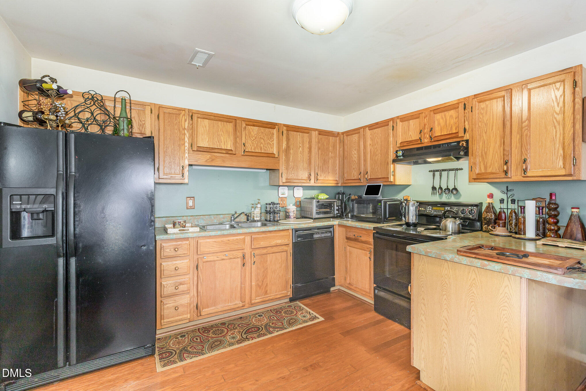 8516 Dunlee Falls Road Raleigh, NC 27613 - Photo 3 of 21 a kitchen with granite countertop a refrigerator stove top oven and sink