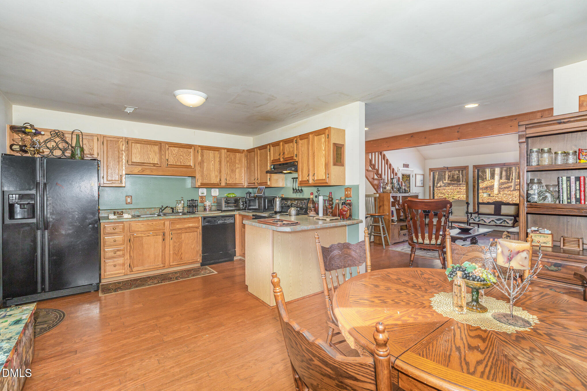 8516 Dunlee Falls Road Raleigh, NC 27613 - Photo 6 of 21 a kitchen with stainless steel appliances granite countertop a refrigerator a stove a sink a dining table and chairs with wooden floor