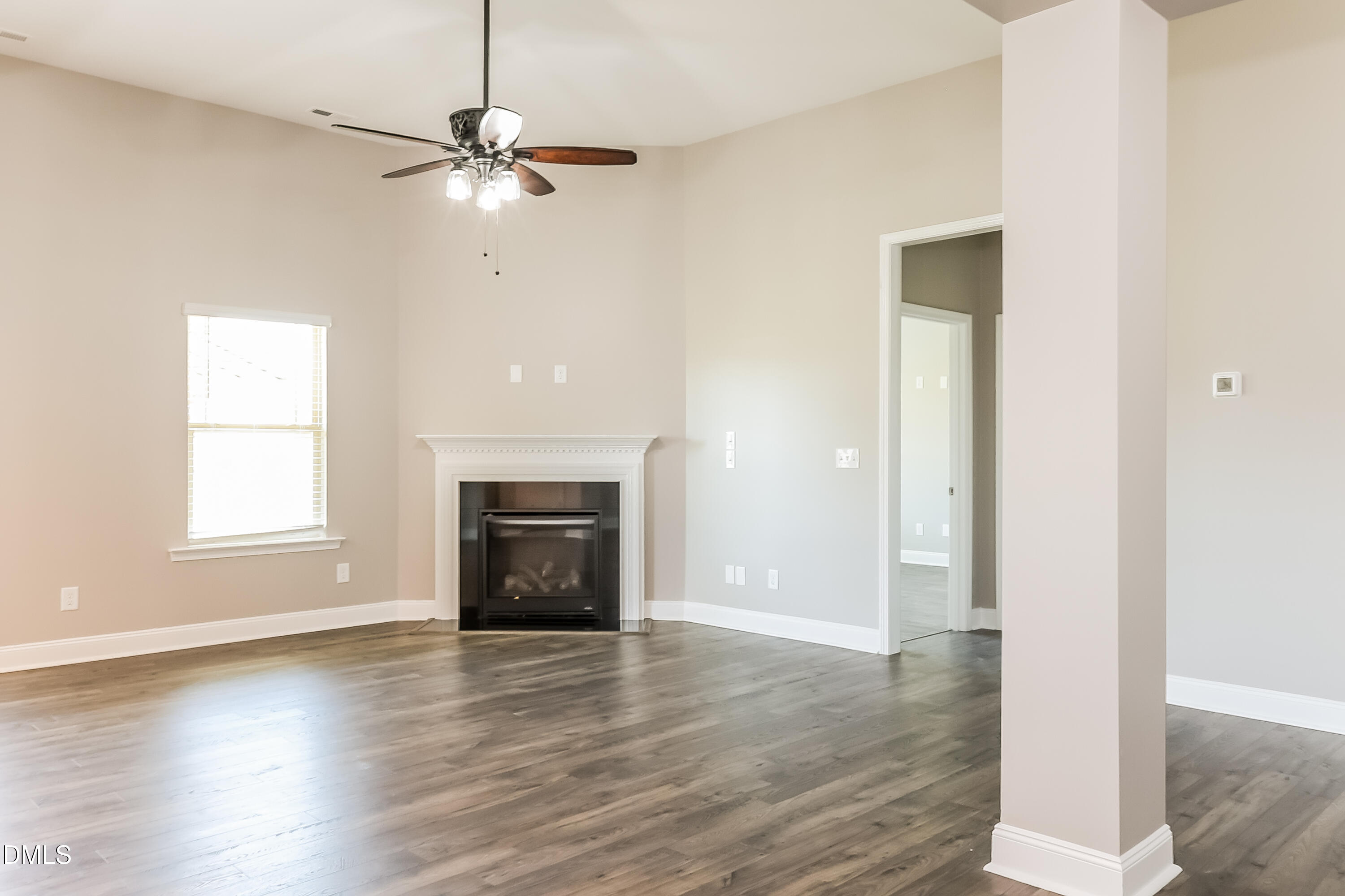 96 Longo Lane Benson, NC 27504 - Photo 2 of 16 an empty room with wooden floor fireplace and windows
