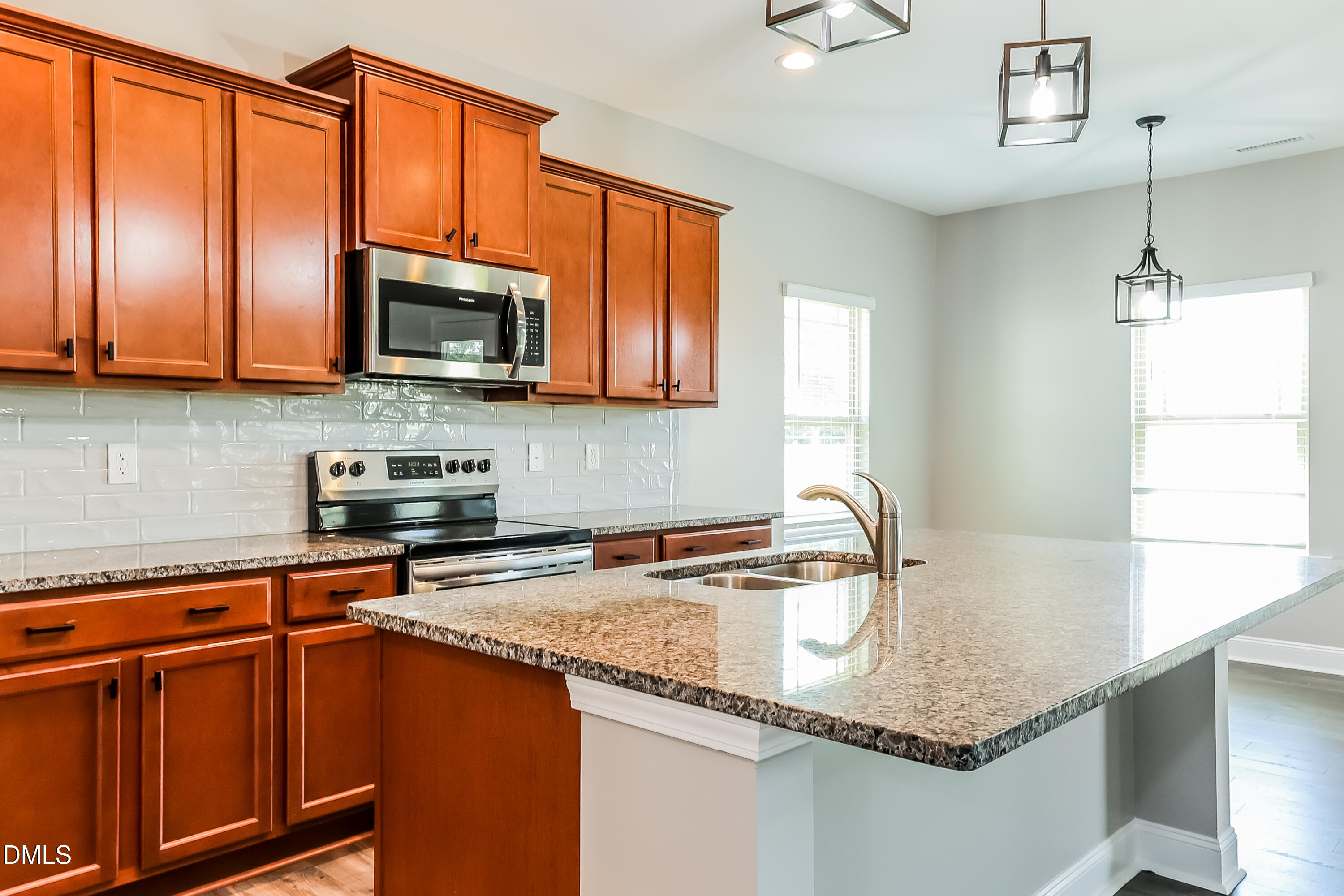 96 Longo Lane Benson, NC 27504 - Photo 7 of 16 a kitchen with stainless steel appliances granite countertop a sink a microwave cabinets and a window