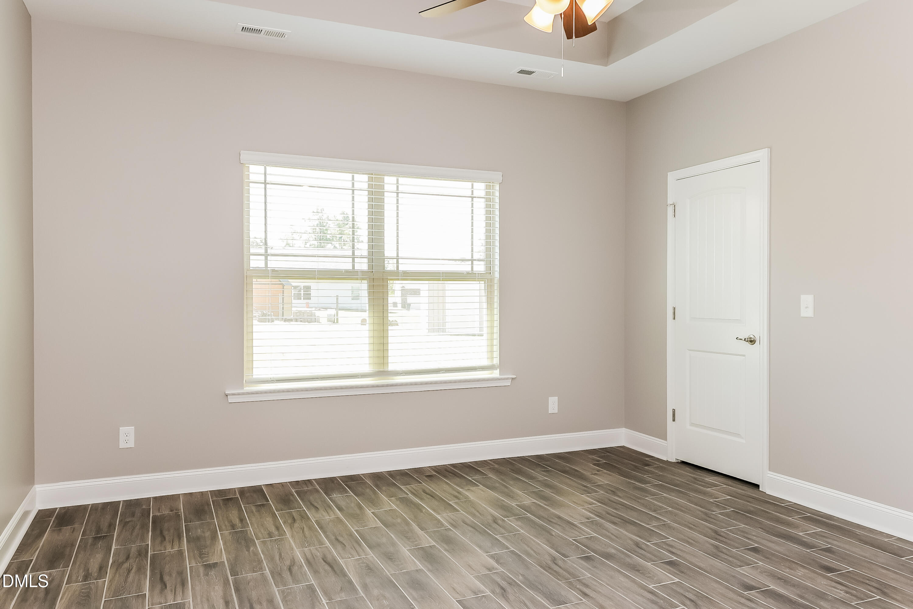 96 Longo Lane Benson, NC 27504 - Photo 8 of 16 an empty room with wooden floor and windows