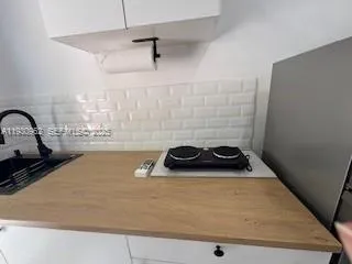 a close view of a sink a stove and kitchen counter top space