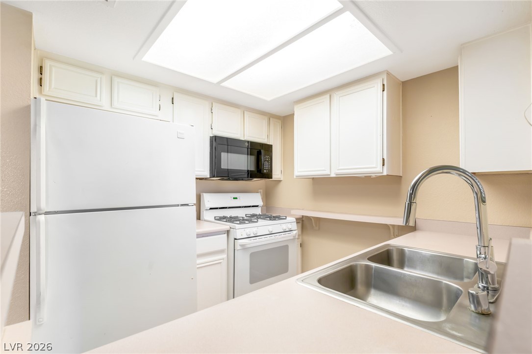 8070 West Russell Road, Unit 1054 Las Vegas, NV 89113 - Photo 10 of 22 A well-appointed kitchen features a double-basin sink and essential appliances for daily living.