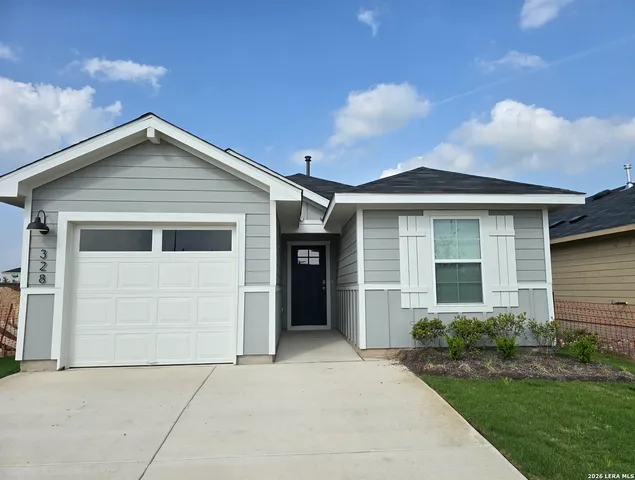a front view of a house with a garden and garage