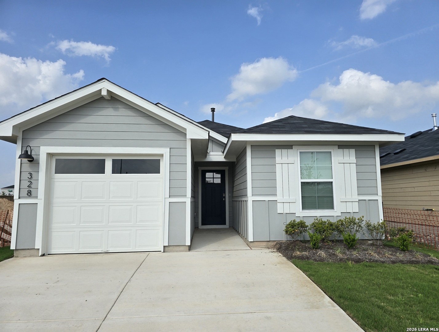 a front view of a house with a garden and garage