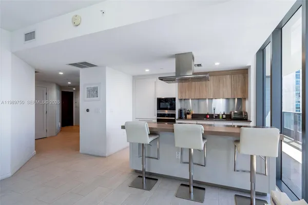 a kitchen with kitchen island a dining table and chairs
