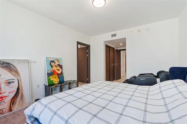 a bedroom with a bed and painting on the wall