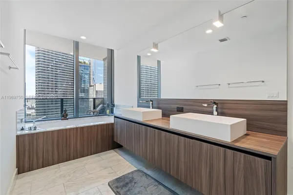 a bathroom with double vanity and a bathtub