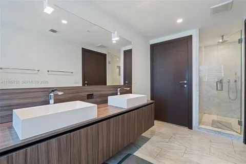 a bathroom with double sink and a mirror