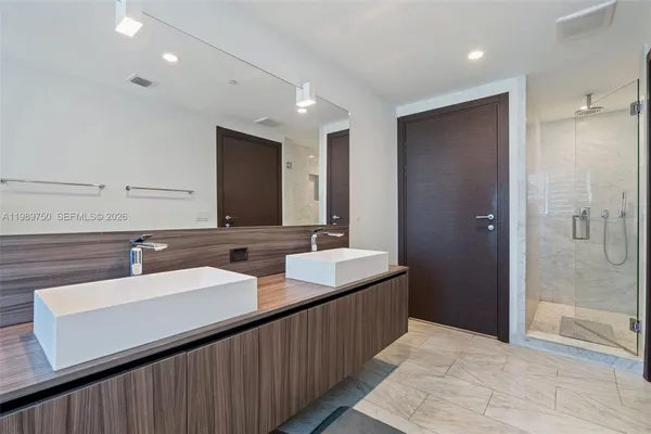 a bathroom with double sink and a mirror